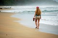 A young woman walks alone on the beach