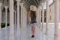 Young woman walks along the antique hall with columns. Ancient city