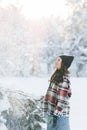 Young woman walks in forest among snow covered pine trees against snowflakes background Royalty Free Stock Photo