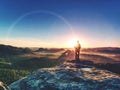 Young woman walks on hill above mist. Strong daybreak sun Royalty Free Stock Photo