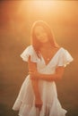 Young woman walks in meadow at sunset Royalty Free Stock Photo