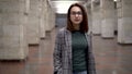 A young woman walks in the subway. A girl in a coat and glasses Royalty Free Stock Photo