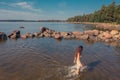 A young woman walks on the water. Lady bathes. Concept of summer vacation, skin and health care, relaxation