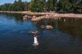 A young woman walks on the water. Lady bathes. Concept of summer vacation, skin and health care, relaxation