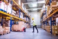 Woman warehouse worker with hand forklift truck. Royalty Free Stock Photo