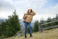 Young woman in warm clothes near conifer forest. Winter