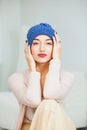 Young woman in warm dark blue hand knitted hat at home. Royalty Free Stock Photo