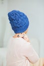 Young woman in warm dark blue hand knitted hat at home. Royalty Free Stock Photo