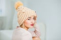 Young woman in warm hand knitted hat at home. Royalty Free Stock Photo