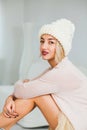 Young woman in warm hand knitted hat at home. Royalty Free Stock Photo