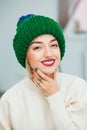 Young woman in warm hand knitted hat at home. Royalty Free Stock Photo