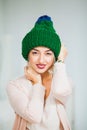 Young woman in warm hand knitted hat at home. Royalty Free Stock Photo