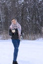 Young woman in warm shawl in winter snowy forest drinks hot tea. Full-length portrait,  Mug and thermos in his hands, hot drink Royalty Free Stock Photo