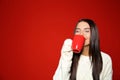 Young woman in warm sweater with cup of hot drink on background. Space for text Royalty Free Stock Photo