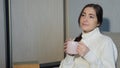 Young woman in warm sweater sitting on sofa and and drinking tea at home Royalty Free Stock Photo