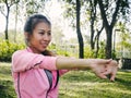 Young woman warm up her body by stretching her arms to be ready for exercising and do yoga in the park.