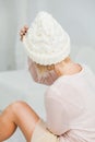 Young woman in warm white hand knitted hat at home Royalty Free Stock Photo