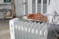 Young woman warming hands near modern electric heater indoors, closeup Royalty Free Stock Photo