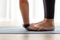 Young woman warming up her wrists in padahastasana yoga pose Royalty Free Stock Photo