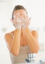 Young woman washing face in bathroom Royalty Free Stock Photo