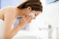 Woman washing face with clean water in bathroom Royalty Free Stock Photo