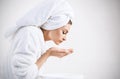 Young woman washing face with clean water.