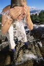 Young woman washing face in river Royalty Free Stock Photo