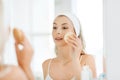 Young woman washing face with sponge at bathroom Royalty Free Stock Photo