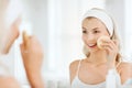 Young woman washing face with sponge at bathroom Royalty Free Stock Photo