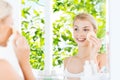 Young woman washing face with sponge at bathroom Royalty Free Stock Photo