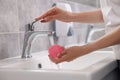 Young woman washing face sponge in bathroom, closeup Royalty Free Stock Photo