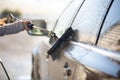 Young woman washing her car in a manual carwash Royalty Free Stock Photo