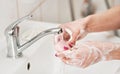 Young woman washing her hands under water tap faucet with soap. Detail on suds covered skin. Personal hygiene concept - Royalty Free Stock Photo