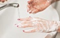 Young woman washing her hands under water tap faucet with soap. Detail on suds covered skin. Personal hygiene concept Royalty Free Stock Photo