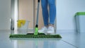 young woman washing white kitchen floor with special swob, cleaning service, close-up