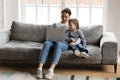 Young woman watching funny movies on computer with kid son.