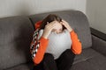 Young woman watching a horror movie, sitting scared, hugging a pillow Royalty Free Stock Photo
