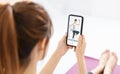 Young  woman watching mobile phone training lesson app  doing exercises at home Royalty Free Stock Photo