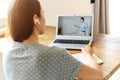 A young woman watching online classes at home