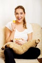 Young woman watching TV and eating chips Royalty Free Stock Photo