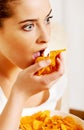 Young woman watching TV and eating chips Royalty Free Stock Photo