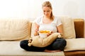 Young woman watching TV and eating chips Royalty Free Stock Photo