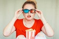 Young woman watching TV sitting on couch with 3d glasses and pop Royalty Free Stock Photo