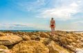 Young woman waving scarf in wind at beach. Happy woman in red bikini holding tissue and looking away at sea. Royalty Free Stock Photo