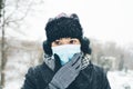 Young woman wear face mask for sickness coronavirus protection. Female person hold hand on it and think. Fear of