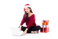 Young woman wear santa hat and gift box sitting labtop with internet shopping online Royalty Free Stock Photo