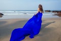 Young woman wearing beautiful wedding blue long dress on the tropical beach.Mermaid girl butterfly wings running along Royalty Free Stock Photo