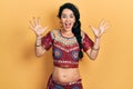 Young woman wearing bindi and bollywood clothing celebrating crazy and amazed for success with arms raised and open eyes screaming