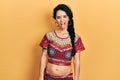 Young woman wearing bindi and bollywood clothing sticking tongue out happy with funny expression