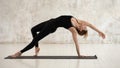 Woman practicing yoga, standing in standing in Wild Thing, Camatkarasana